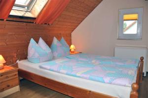 KrumminFerienwohnung Krummin USE 2981的一间卧室配有一张带蓝色和紫色枕头的床