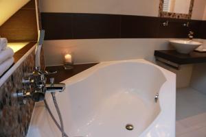 Troskovice瑞卡尔旅馆的带浴缸的浴室和水槽