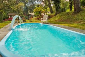 坎波斯杜若尔当Villa Vintage Campos - Piscina e opções de suites com hidromassagem的一个带水滑梯的大型蓝色游泳池