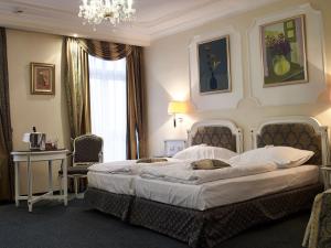 玛丽亚温泉滨海温泉高尔夫度假酒店的一间卧室配有一张大床和一个吊灯。