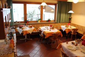 波斯特尔Gruberhof的餐厅设有4张带黄桌布的桌子