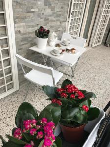 罗马罗马甜蜜之家公寓的阳台上配有带鲜花的桌椅