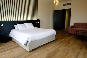 穆瓦萨克穆瓦萨克穆勒Spa酒店 的卧室配有一张白色大床和一把椅子