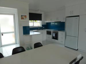 布里德波特Central Location with Fabulous Sea Views的白色的厨房配有桌子和冰箱