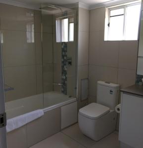 卡伦德拉绿洲私人两床公寓的浴室配有卫生间、浴缸和水槽。