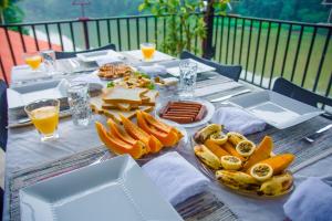 康提Chaminrich Homestay的餐桌上摆放着食物和饮料