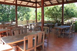 盼武里河畔度假酒店的户外餐厅设有木桌和椅子