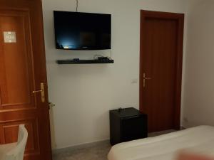 钱皮诺罗马钱皮诺甜蜜生活旅馆的一间卧室配有一张床,墙上配有电视