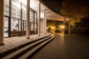 博洛尼亚弗莱昂酒店及会议中心的一座在晚上有长凳的建筑