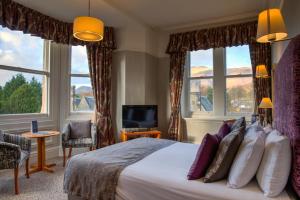 凯西克凯斯维克乡村别墅酒店的一间卧室配有一张带窗户的大床和电视。