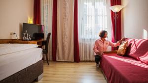 阿尔蔡施洛斯酒店的坐在酒店房间,望向窗外的女人