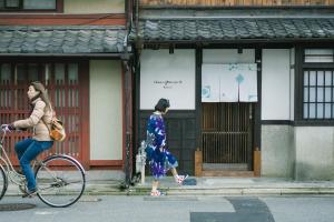 京都京町家旅宿 大雲的两个女人骑着自行车沿着街道走
