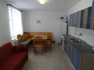 VápennáU Nás - Apartmán Jelen的一间带红色沙发和桌子的厨房和一间带桌面的厨房