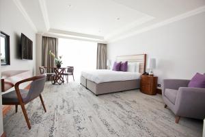 伦敦Sanctum Maida Vale的酒店客房,配有一张床、一张桌子和椅子