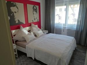 奥格斯堡斯坦恩豪瑟之家公寓的卧室配有白色的床铺和红色的墙壁