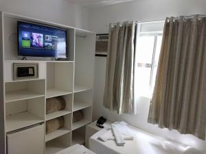 巴拉奈里奥-坎布里乌Master Hotel的浴室设有白色架子上的电视