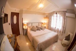 圣若阿金Chalé Alto da Serra - Pousada & Wellness Spa的一间卧室设有一张大床和一个窗户。