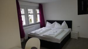FrastanzGasthaus Sofram的一间卧室配有带白色床单和枕头的床。