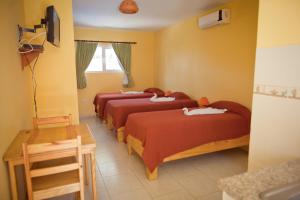 喀巴里特风筝海滩酒店 的黄色墙壁的房间里设有三张床