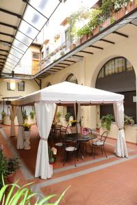 佛罗伦萨拉康缇希纳酒店的一个带桌椅的白色遮阳伞下庭院