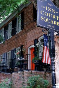 夏洛茨维尔Inn at Court Square的一座悬挂美国国旗的建筑前的标志