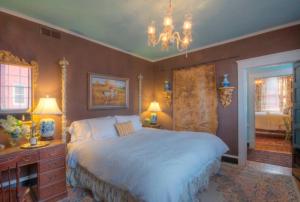 夏洛茨维尔Inn at Court Square的一间卧室配有一张大床和一个吊灯。