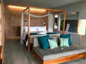 普卢坎Umadewi Surf & Retreat的一间卧室配有天蓬床和带枕头的长凳