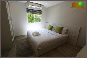 曼谷 普里玛住宿酒店 - SHA Certificate的一间卧室配有一张带绿色枕头的床和一扇窗户