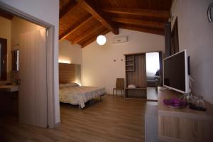 斯廷蒂诺Agriturismo al Riparo dai Venti的一间卧室配有一张床和一台平面电视