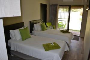 布隆方丹Dante Deo Guesthouse的酒店客房,配有两张带绿毛巾的床