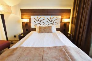 厄斯特松德厄斯特松德酒店的卧室配有一张白色大床和木制床头板