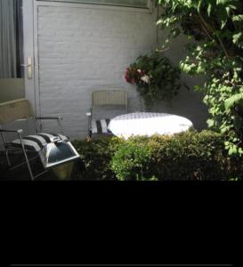 埃因霍温Suite 17的庭院设有两把椅子和长凳,鲜花盛开。