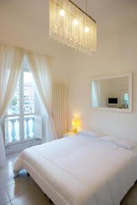 莱里奇Vittoria的白色的卧室设有一张大床和一个窗户