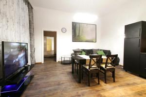 维也纳拉纳公寓的客厅配有餐桌和电视