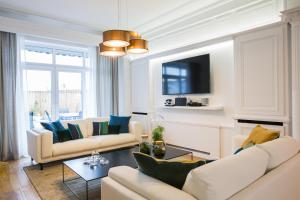 里尔Luxueux logement Bourgeois de 250 M2 climatisé的客厅配有两张沙发和一台电视机