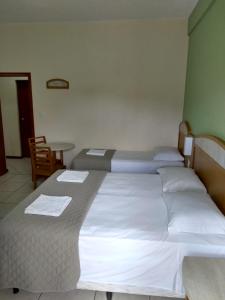 里奥格兰德波萨达伊斯奎纳度索尔酒店的酒店客房设有三张床和一张桌子