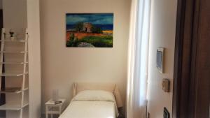 穆罗莱切塞安迪科卡米诺住宿加早餐酒店的一间设有一张床的客房,墙上挂着一幅画