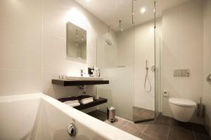 哈尔德韦克Hotel Bella Ciao的带浴缸、卫生间和淋浴的浴室。