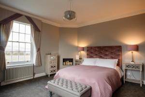 威克福德B&B Downham Hall的一间卧室设有一张床和一个大窗户