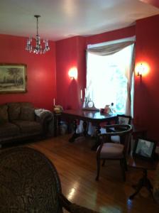 DauphinSir Edgar House B&B的客厅设有红色的墙壁和桌子