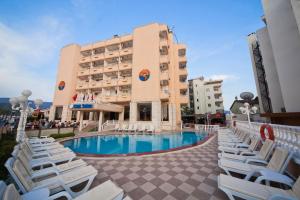 马尔马里斯新纶酒店的一座建筑前的带椅子和游泳池的酒店
