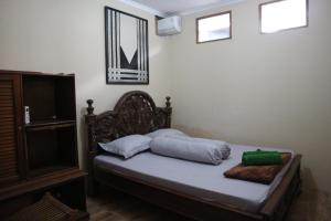 日惹肯巴尔住宿加早餐旅馆的一间卧室配有带枕头的床