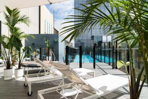 墨尔本阿德菲酒店的一个带躺椅的阳台和一个游泳池