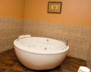 帕拉马里博舍瓦酒店的带浴缸的浴室和瓷砖墙