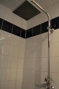 埃因霍温Suite 17的浴室铺有黑白瓷砖,设有淋浴。