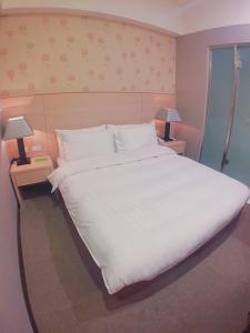 台北皇家饭店的一张大白床,位于带两盏灯的房间