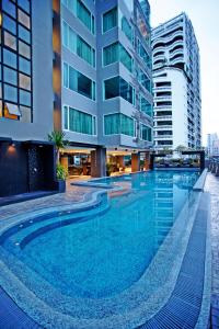 曼谷金色郁金香麦迪逊套房酒店的大楼前的大型游泳池