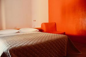 圣阿尔坎杰洛-迪罗马涅Villa Greta的配有一张床和一把椅子的酒店客房
