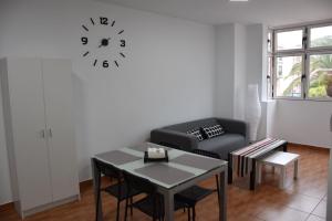 阿里纳加Apartamento Quintana的客厅配有沙发和墙上的时钟
