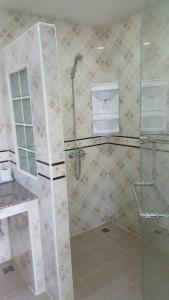 七岩攀亚之地酒店的浴室里设有玻璃门淋浴